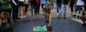 Una ragazza posa dei fiori sulla Rambla di Barcellona dopo l'attentato