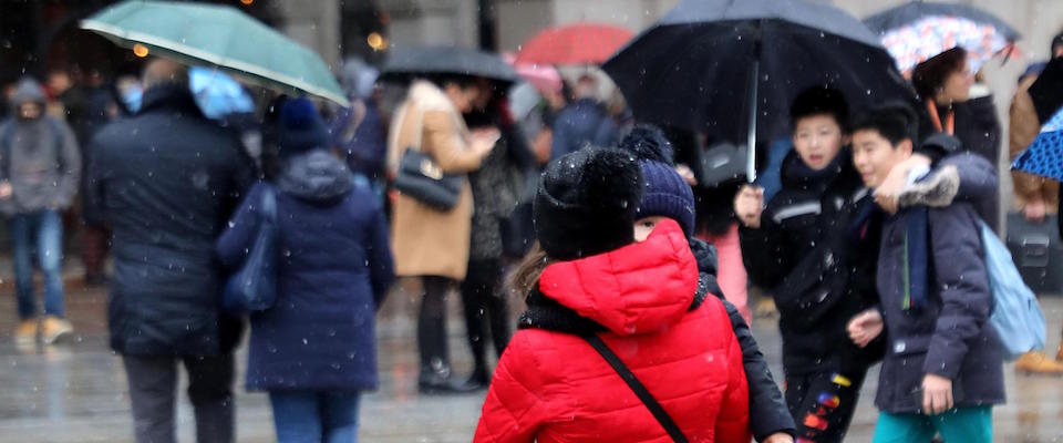 Una mamma con il proprio bambino in piazza del Duomo a Milano dove cade una pioggia mista a neve, Milano, 13 dicembre 2019.
ANSA / MATTEO BAZZI