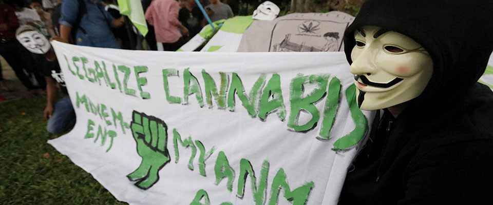 epa07988477 People wearing Guy Fawkes masks hold a banner during a gathering of Myanmar’s Legalize Cannabis Movement at Maha Bandula Park in Yangon, Myanmar, 11 November 2019. The possession, production and sale of marijuana and hemp are illegal in Myanmar and carry severe penalties.  EPA/NYEIN CHAN NAING