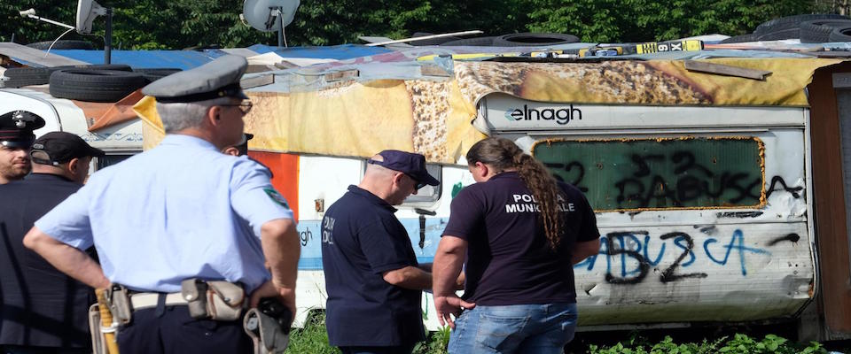 Polizia municipale durante lo sgombero del campo nomadi di corso Tazzoli dopo l’incendio che aveva distrutto numerose baracche, Torino, 5 giugno 2018. Il campo abusivo di corso Tazzoli era sorto 13 anni fa. Molte le famiglie che avevano gi‡ lasciato da soli le baracche, che saranno ora demolite. Il Comune ha gi‡ predisposto l’accoglienza temporanea, per chi ne avesse necessit‡, nella palestra della protezione civile e in un’area attrezzata con tende della Croce Rossa in via Onorato Vigliani, mentre le persone con problemi medici sono state affidate a strutture sanitarie. ANSA/ALESSANDRO DI MARCO