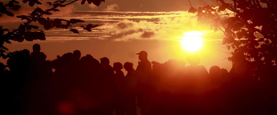 epa07665111 People watch sunset at sea in summer at the solstice festival in Jurkalne, Latvia, 21 June 2019. On the longest day and the shortest night of the year, people gather to celebrate the mythological holiday of the Latvian season – Summer solstice. During these festivities, people participate together festive rituals and spend all night in the light of the fire.  EPA/Toms Kalnins