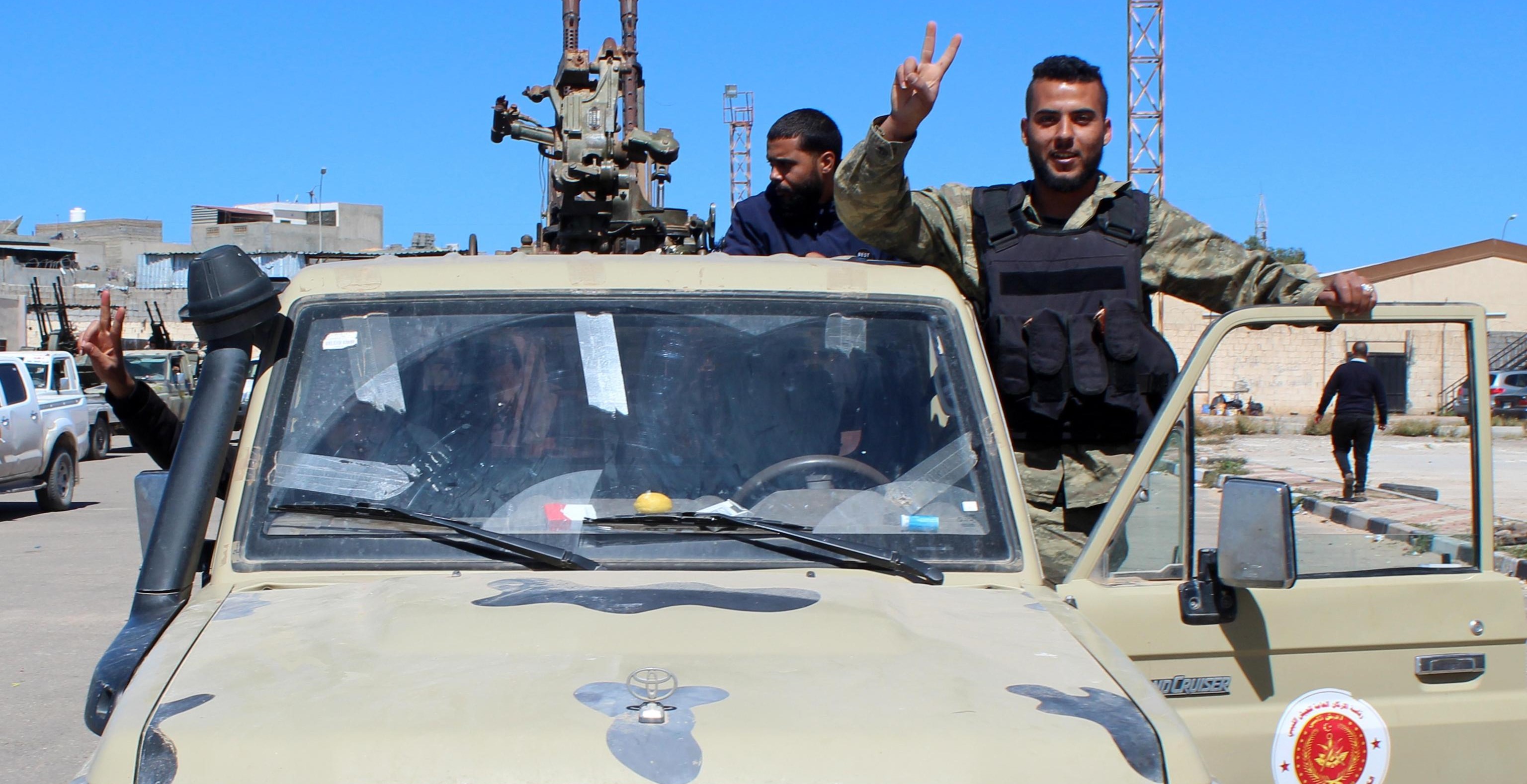 epa07492507 Militants, reportedly from the Misrata militia, flash the victory sign as they gather before heading to the frontline to join forces defending the capital, in Tripoli, Libya, 08 April 2019. Commander of the Libyan National Army (LNA) Khalifa Haftar on 04 April ordered Libyan forces loyal to him to take the capital Tripoli, held by a UN-backed unity government, sparking fears of further escalation in the country. The UN said thousands had fled the fighting in Tripoli, while ministry of health reported 25 people, including civilians, were killed in the fighting.  EPA/STRINGER   ALTERNATIVE CROP