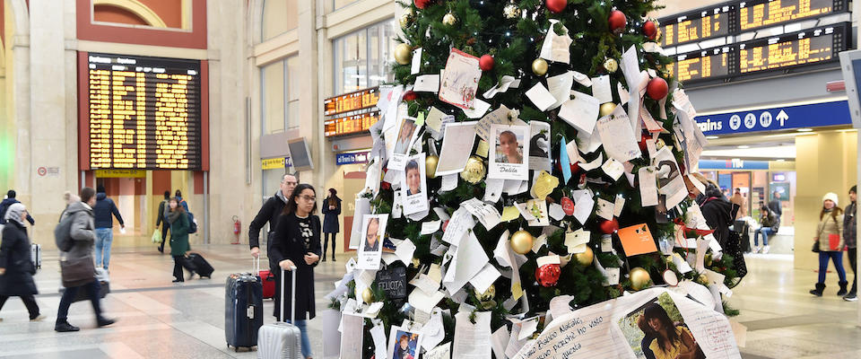 Passeggeri passano accanto albero di
Natale esposto nella stazione ferroviaria di Porta Nuova a
Torino parzialmente ricoperto questa mattina dalle foto di
bambini coinvolti nelle adozioni a Bibbiano comparse appese insieme alle lettere
di Natale,3 gennaio 2020. ANSA/ALESSANDRO DI MARCO