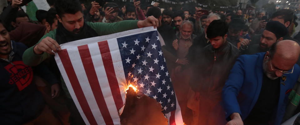 epa08100304 Pakistani Shiite Muslims burn a mock of a US flag as they  hold pictures of General Qasem Soleimani, the head of Iran’s Islamic Revolutionary Guard Corps’ elite Quds Force, during a protest against the USA, outside the US Consulate in Lahore, Pakistan, 03 January 2020. General Qasem Soleimani, was killed in an airstrike on 03 January, in Baghdad ordered by the United States president, the Pentagon said. General Soleimani was in charge of Iran’s foreign policy strategy as the head of the Quds Force, an elite wing of the Islamic Revolutionary Guard Corps, which the US designated as a terror organization. The Quds Force holds sway over a raft of Shia militias across the region, from Lebanon to Syria and Iraq.  EPA/RAHAT DAR