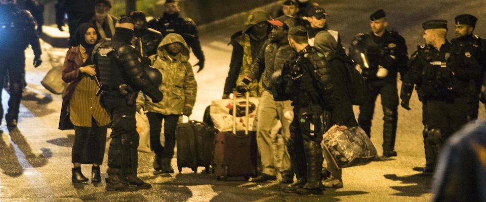 epa07977891 Migrants wait to get onto a bus during a police operation to clear makeshift camps in the north of Paris, France, early 07 November 2019. During a presentation of the French government’s immigration policy on 06 November, French Interior Minister Christophe Castaner announced that camps for irregular migrants in Paris were to be evacuated by the end of the year.  EPA/JULIEN DE ROSA