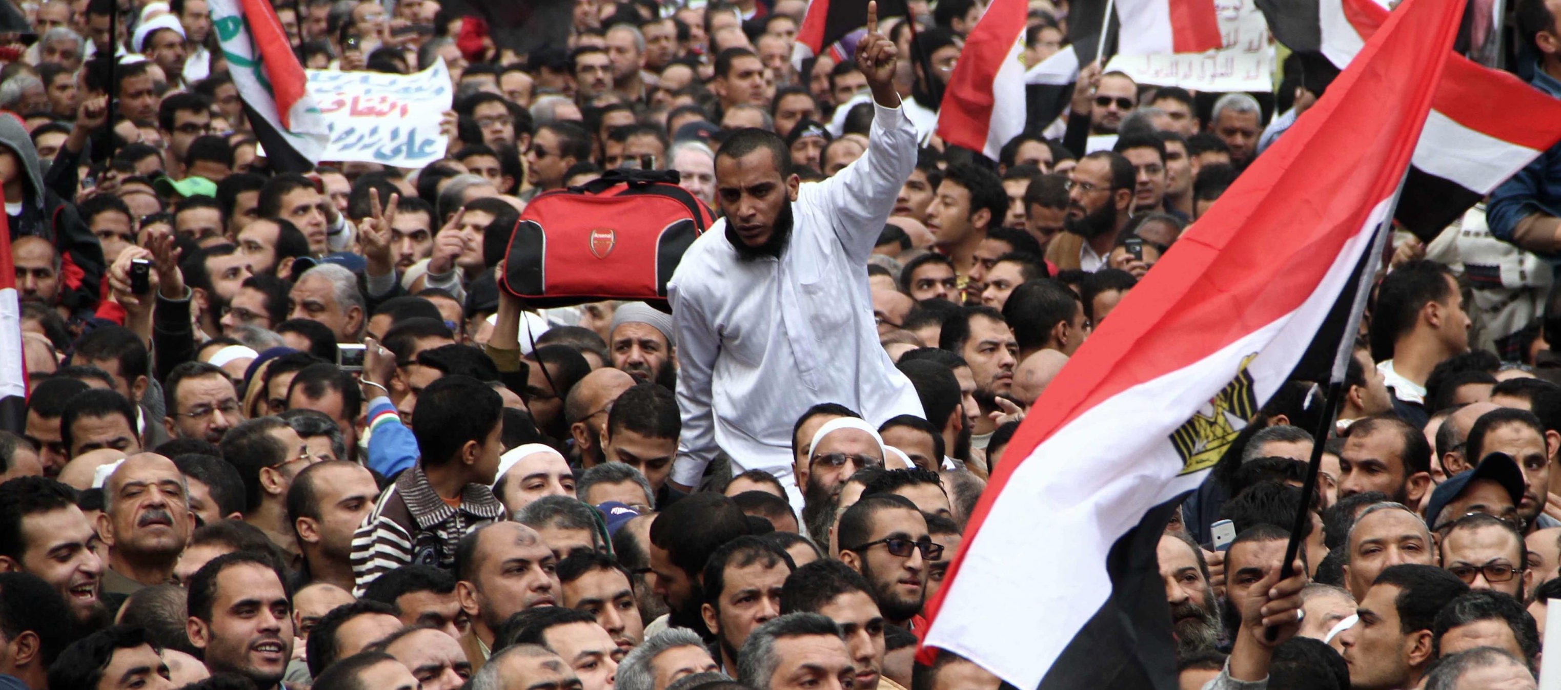 epa03007918 Egyptian protesters hold national flags during a march in Alexandria, Egypt, 18 November 2011. According to media reports, thousand of protesters gathered on 18 November in Cairo for a mass protest against planned constitutional amendments that would establish a civil state in the predominantly Muslim country and give the army the right to veto legislation on military issue.  EPA/AHMED YOUSSEF