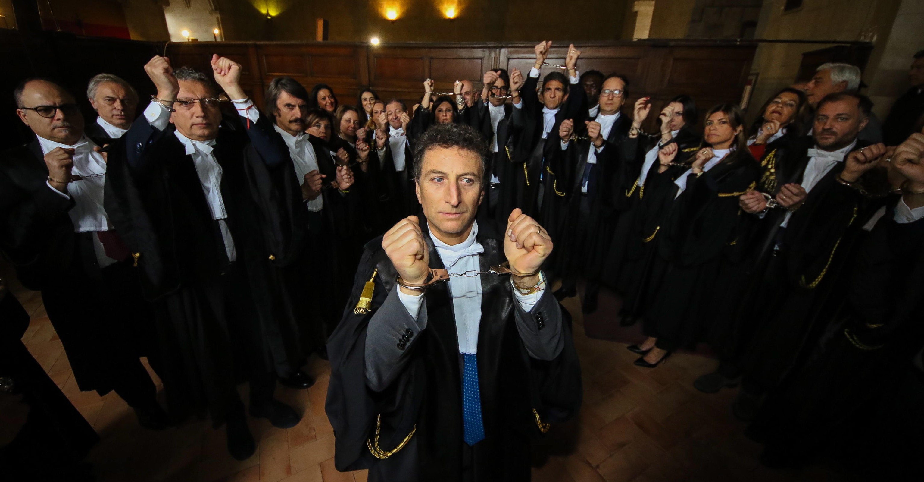 epa08184593 Lawyers demonstrate in handcuffs during a protest at Palazzo di Giustizia (Palace of Justice) for the inauguration of the Judicial Year 2020 in Naples, southern Italy, 01 February 2020. Italian lawyers are protesting against a reform by Minister of Justice Bonafede.  EPA/CESARE ABBATE