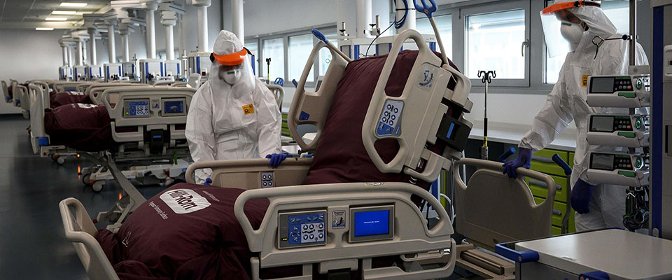 Nurses work to prepare the Intensive care unit in the new Covid-19 Hospital on March 29, 2020 in Verduno, near Alba, Northwestern Italy on the eve of its official opening, as part of the measures taken to fight against the spread of the novel coronavirus. – The hospital have seven beds of intensive care and fifty beds for patients infected by the COVID-19. (Photo by MARCO BERTORELLO / AFP)