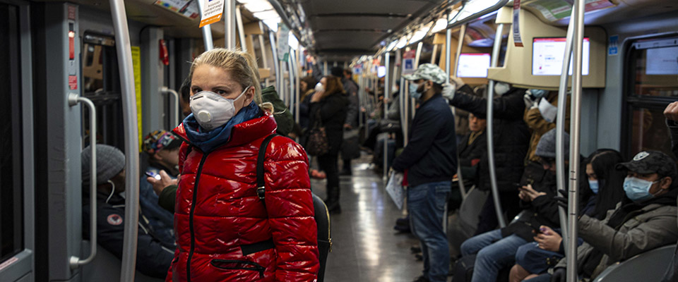 Utenti del servizio pubblico indossano mascherine sanitarie e guanti per viaggiare nelle metropolitana di Milano, 12 Marzo 2020. ANSA/Marco Ottico