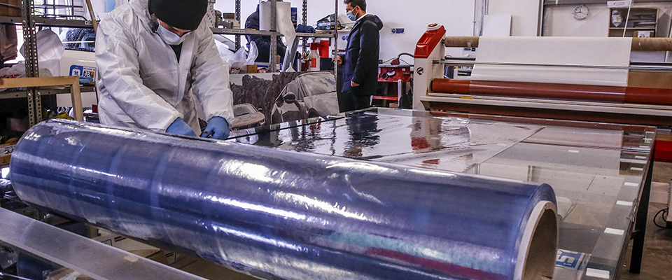 Operai della Giga Print montano su un taxi una separazione trasparente in plastica che permette ai conducenti di lavorare in sicurezza durante l’emergenza del Coronavirus a Roma, 26 marzo 2020, La Giga Print è un azienda che si occupa di stampa grafica realizzazione pannelli e gadget per eventi, su idea del titolare Giorgio Viscione in questi giorni di emergenza coronavirus la piccola azienda ha cambiato volto montanto centinaia di separatori in plastica sui taxi romani oltre a realizzare separatori in plexiglas per farmacie e supermercati.  ANSA / FABIO FRUSTACI