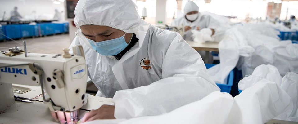 This photo taken on February 28, 2020, shows workers sewing hazardous material suits to be used in the COVID-19 coronavirus outbreak, at the Zhejiang Ugly Duck Industry garment factory in Wenzhou. – The coronavirus outbreak in China is preventing clothing manufacturer Ugly Duck Industry from resuming its normal production of winter coats, so it has pivoted to another in-demand product: hazmat suits. (Photo by NOEL CELIS / AFP) / TO GO WITH AFP STORY HEALTH-VIRUS-CHINA-HAZMAT-FACTORY,SCENE BY DAN MARTIN