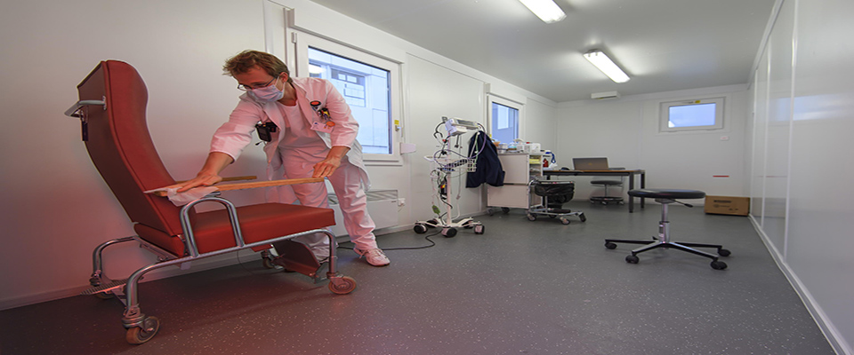 epa08337353 A doctor disinfects a chair after being in contact with a potential COVID-19 patient in a consultation container under a COVID-19 consultation tent in front of the main entrance of the emergency unit of the hospital ‘Hopital cantonal fribourgeois (HFR)’ during the state of emergency of the coronavirus disease (COVID-19) outbreak, in Fribourg, Switzerland, 01 April 2020. Countries around the world are taking increased measures to stem the widespread of the SARS-CoV-2 coronavirus, which causes the COVID-19 disease.  EPA/ANTHONY ANEX PERSPECTIVE DIGITALLY CORRECTED