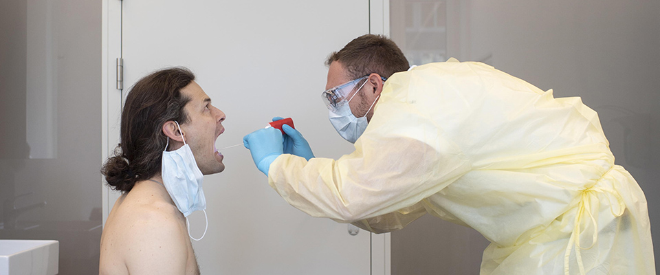 epa08337198 Doctor Raphael Magnolini examines a patient in the COVIC-19 test center of the University of Zurich, Switzerland, 01 April 2020. Countries around the world are taking increased measures to stem the widespread of the SARS-CoV-2 coronavirus which causes the Covid-19 disease.  EPA/ENNIO LEANZA