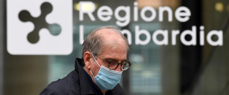 A man walks next to a Lombardia Region sign in Milan, Italy, 20 October 2020. Lombardy has decided to ask the government to institute a curfew in the region from 11 pm to 5 am starting from Thursday 22 October after the ‘Indicators Commission’ set up by the Directorate General for Welfare has predicted that as of 31 October, there could be about 600 hospitalized in intensive care and up to 4,000 in non-intensive care.ANSA/DANIEL DAL ZENNARO