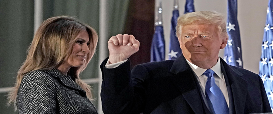 US President Donald J. Trump (R) gestures to guests as he and First lady Melania Trump (L) return to the Residence following the ceremony where Justice Amy Coney Barrett took the oath of office to be Associate Justice of the Supreme Court on the Blue Room Balcony of the White House in Washington, DC, USA, 26 October 2020. ANSA/Ken Cedeno / POOL