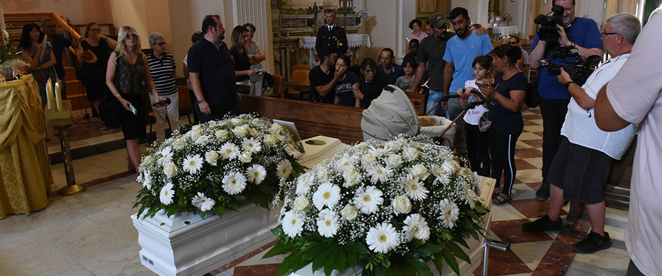 I funerali “in solitudine” dei fratellini rumeni annegati: chiesa semivuota, il dolore dell’arcivescovo