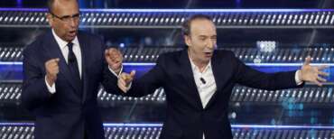 Benigni-show: duetta con Conti, svela il voto di Musk a Giorgia. Poi l’annuncio del ritorno in Rai